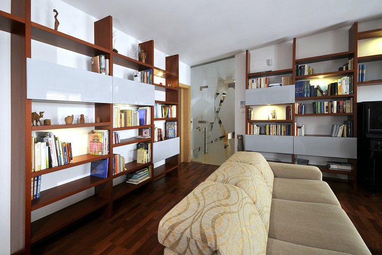 Obývací pokoj s pianem a velkou knihovnou